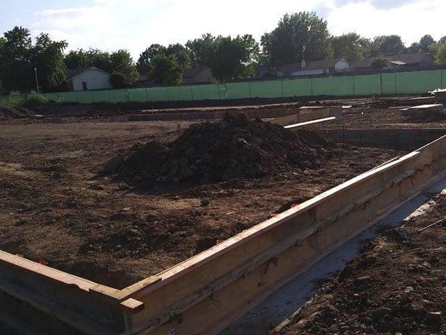 A pile of dirt sits in the middle of a construction site