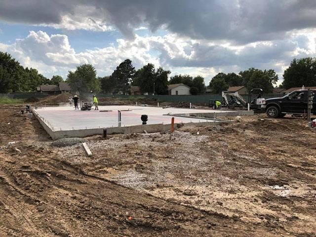 A construction site with a truck parked in the dirt.