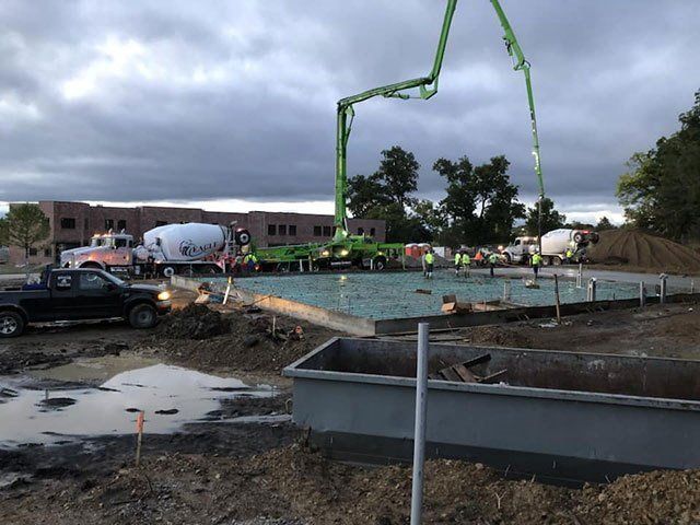 A concrete pump is being used to pour concrete on a construction site.