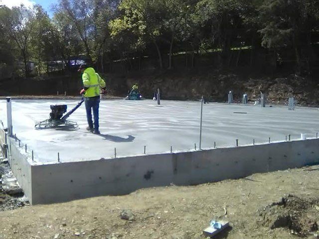 A man is working on a concrete floor with a machine.