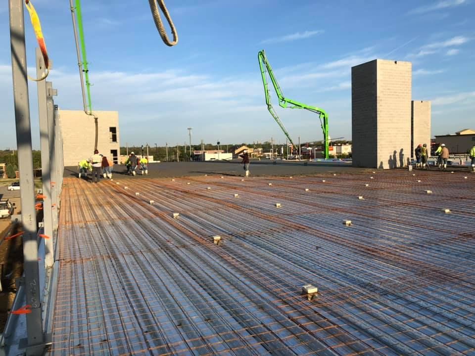 A construction site with a concrete pump in the background.