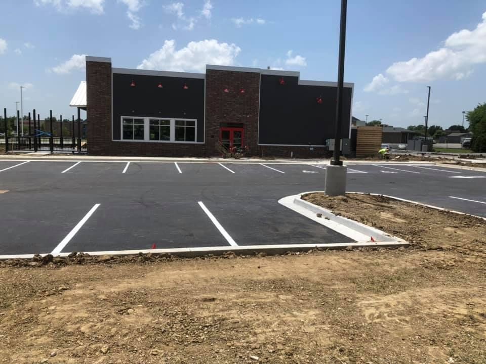A parking lot with a brick building in the background