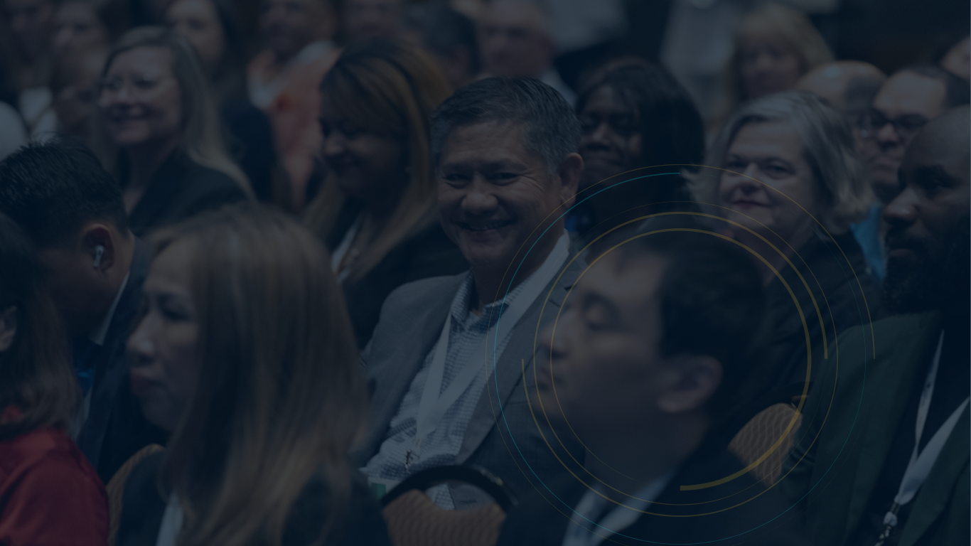 A large group of people are sitting in a dark room.