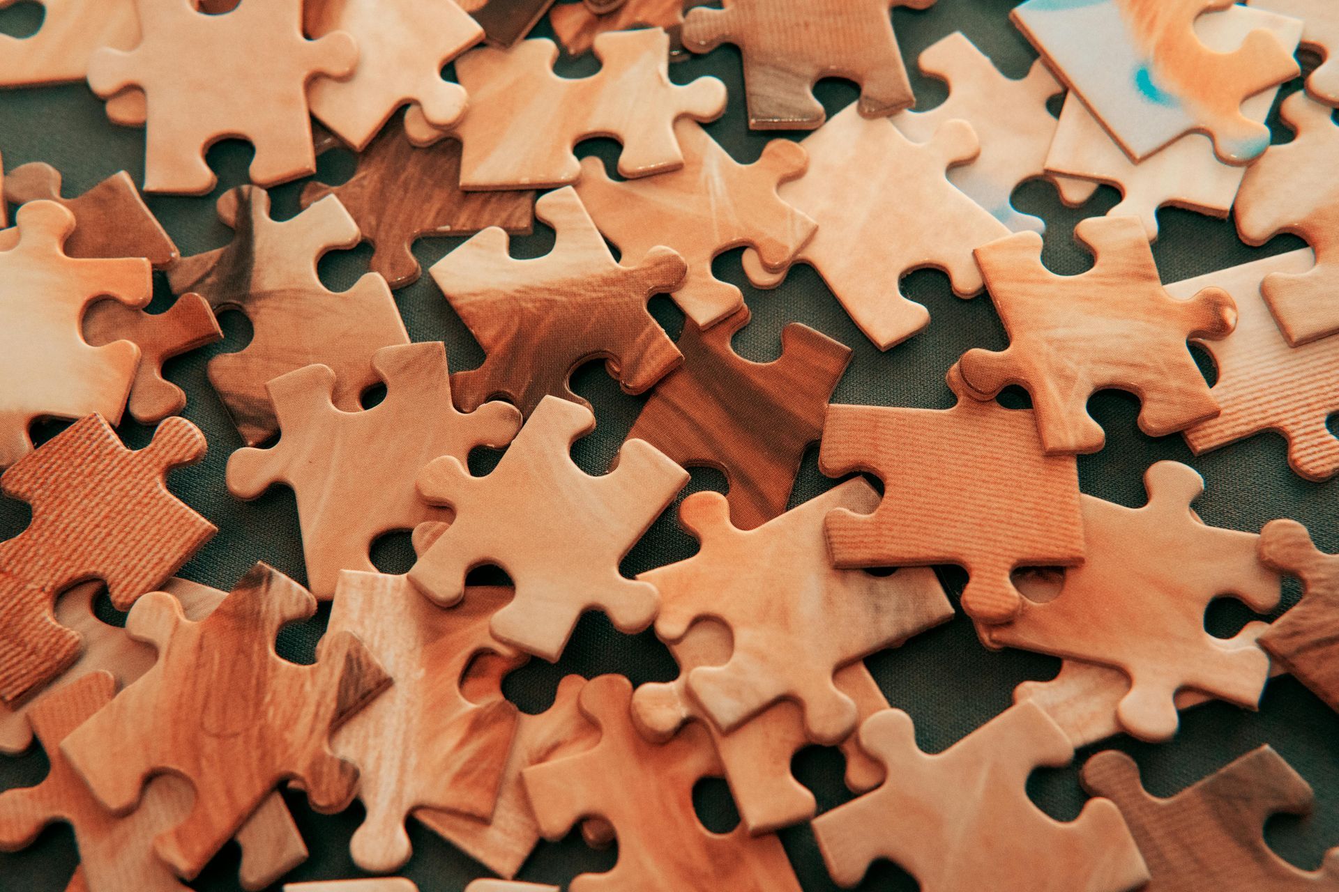 A pile of wooden puzzle pieces on a table.