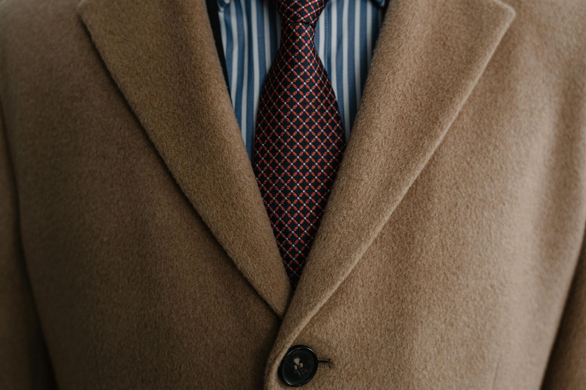 A close up of a man wearing a coat and tie.