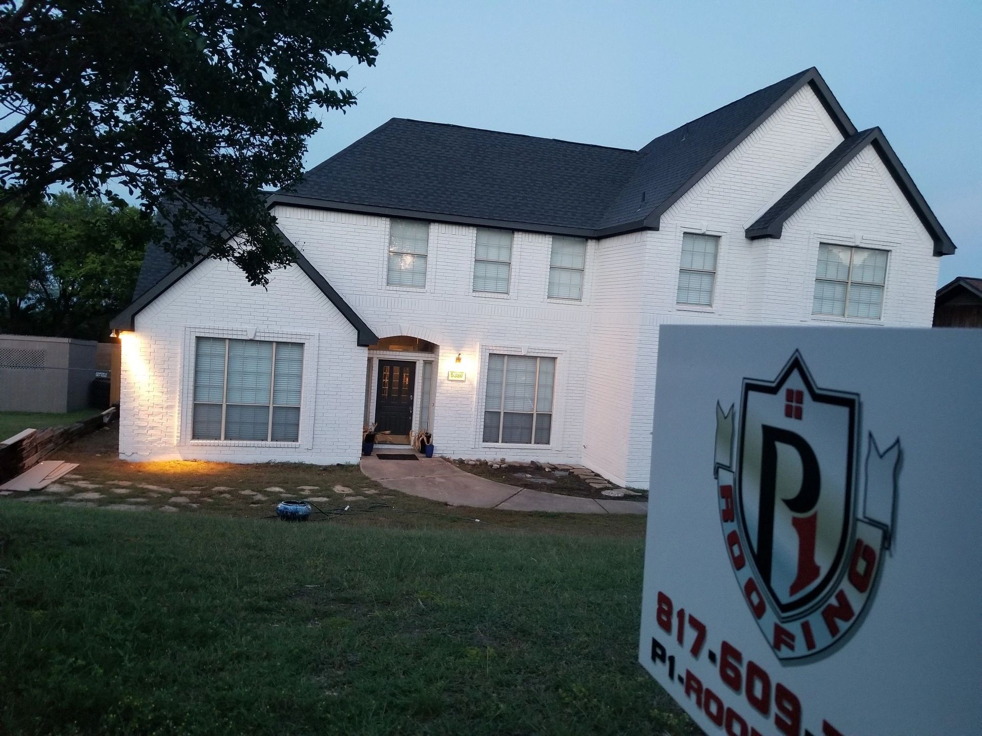 A large white house with a sign in front of it