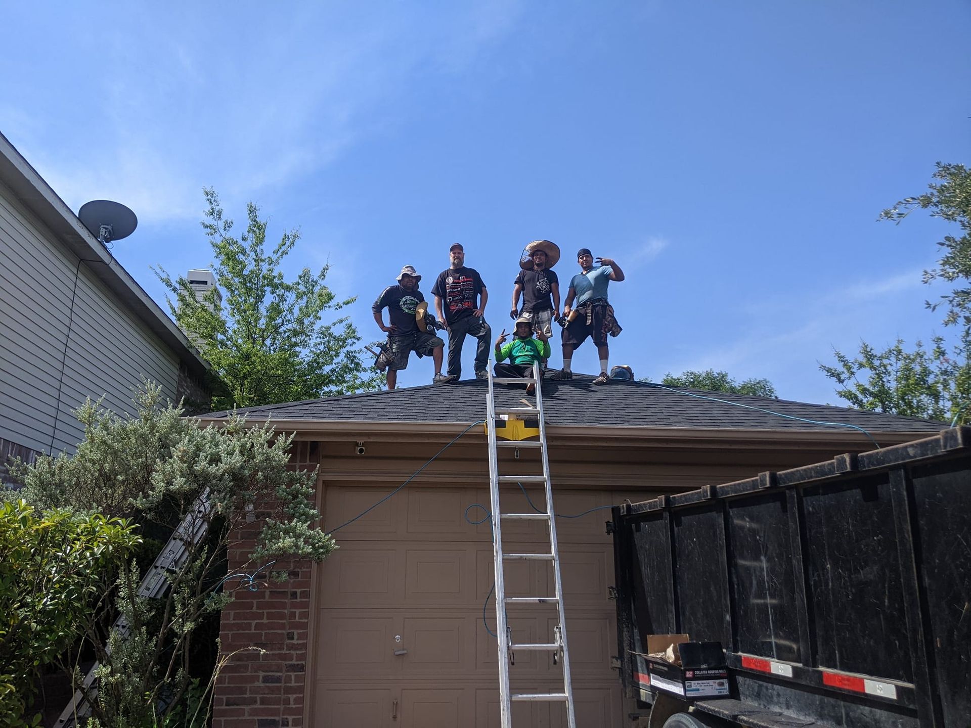 A group of men are standing on the roof of a house.