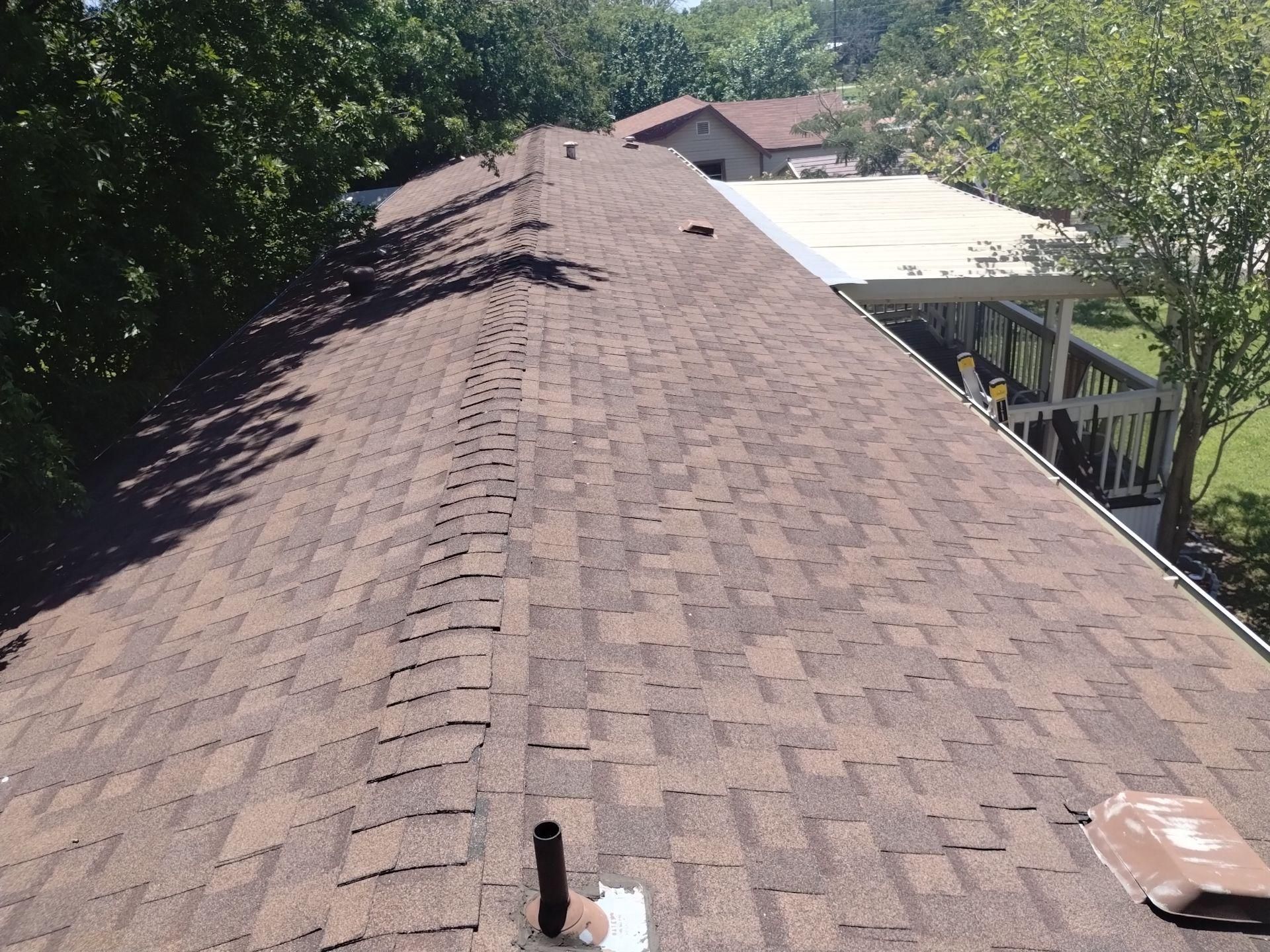 Brown asphalt shingle roof, outdoor, day.