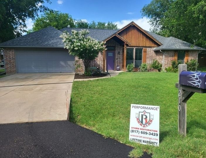 A house with a sign in front of it that says roof warranty