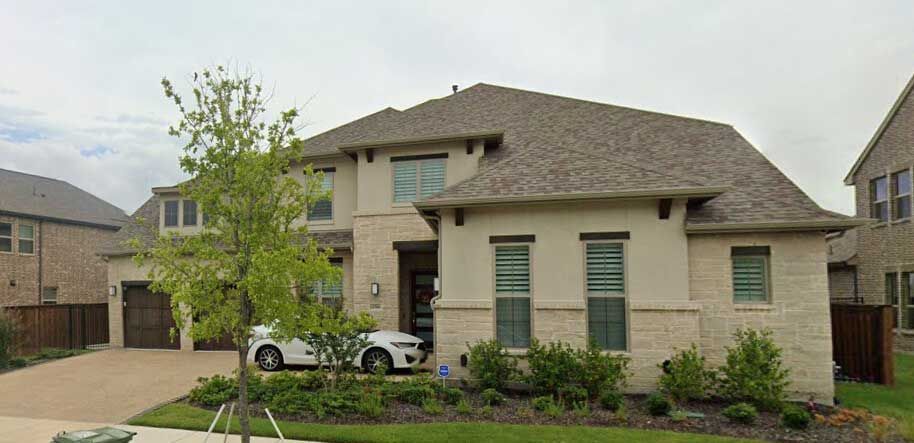A large house with a car parked in front of it.