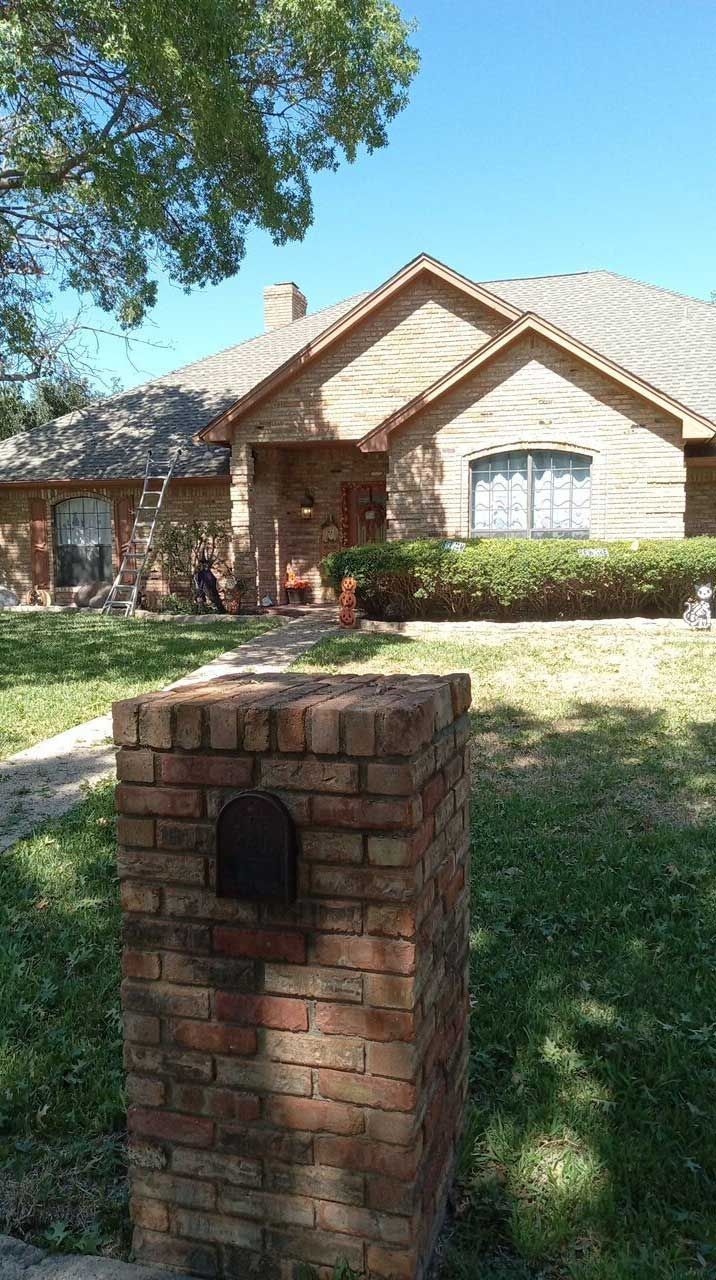 A house with a brick mailbox in front of it.