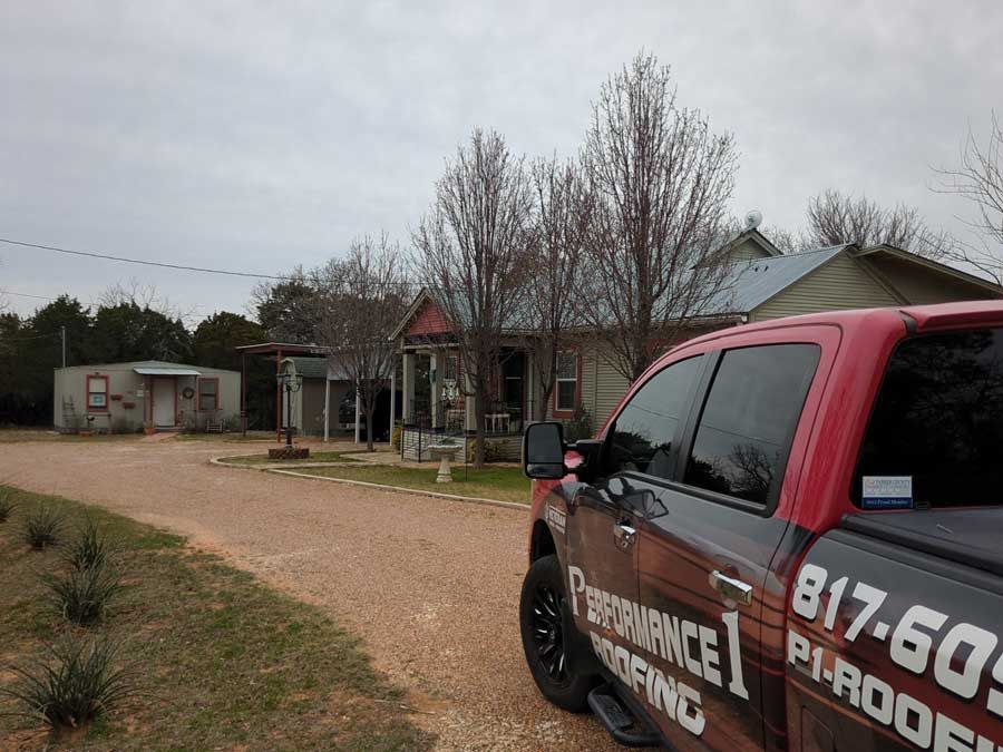 A red truck is parked in front of a house.