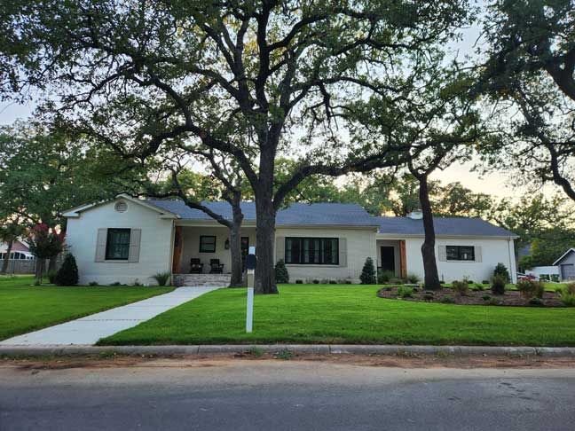 A white house with a tree in front of it