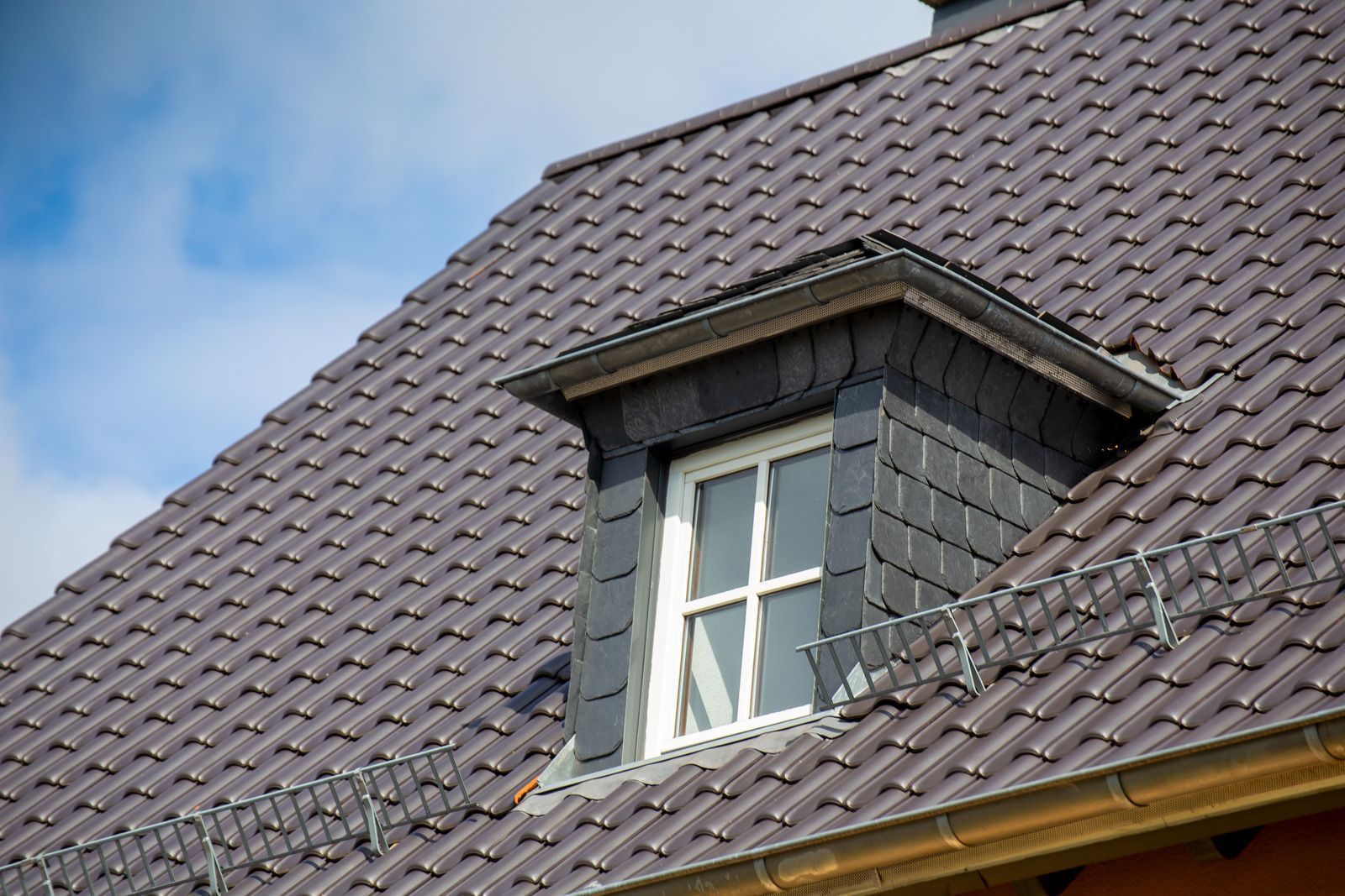 There is a window on the roof of a house.