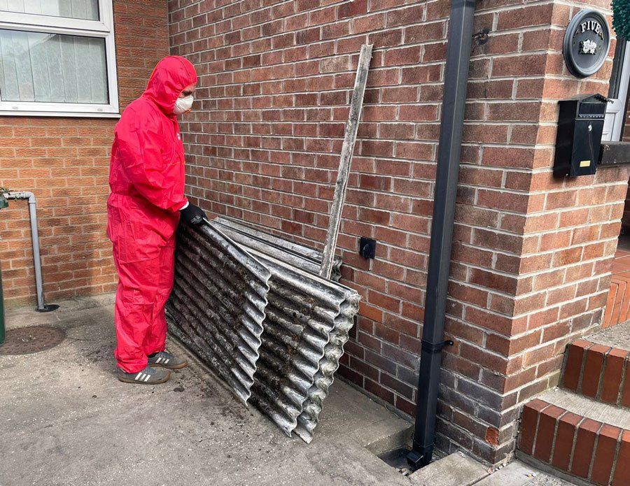 man in red boiler suit removing old roofing sheets