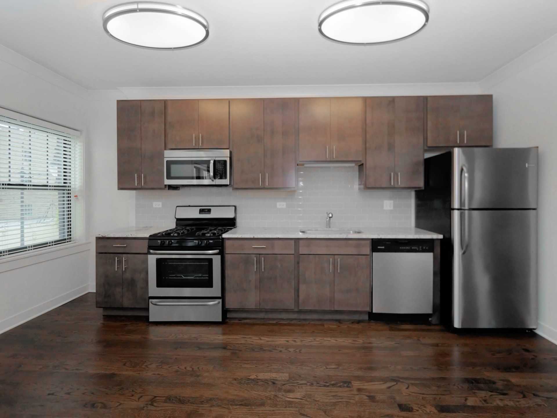 A kitchen with stainless steel appliances and wooden cabinets at 5425 N Clark Street.