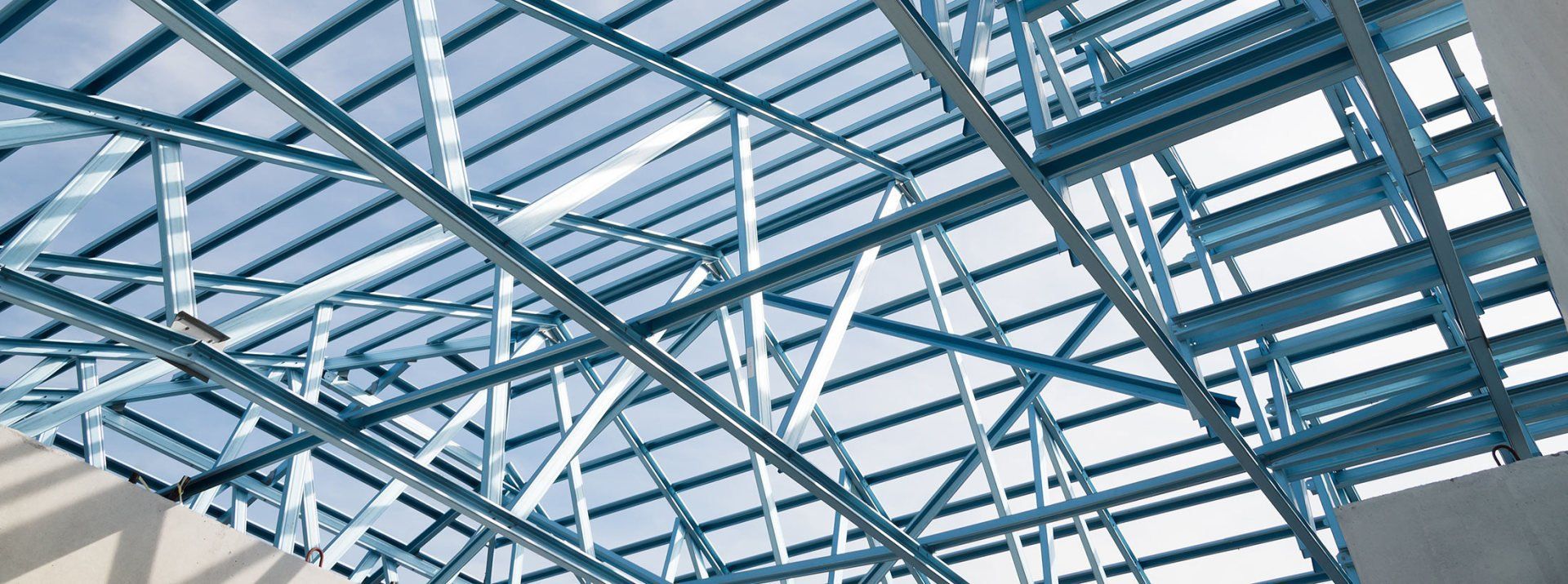 Looking up at the ceiling of a building with a blue sky in the background.