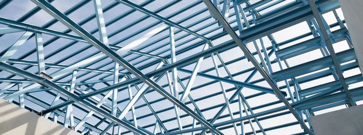 Looking up at the ceiling of a building with a blue sky in the background.