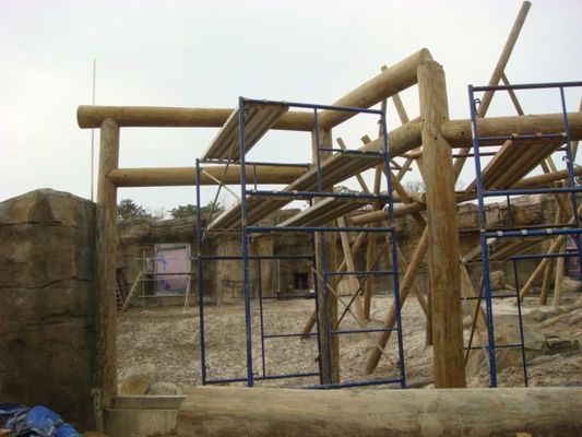 A construction site with scaffolding and wooden pillars