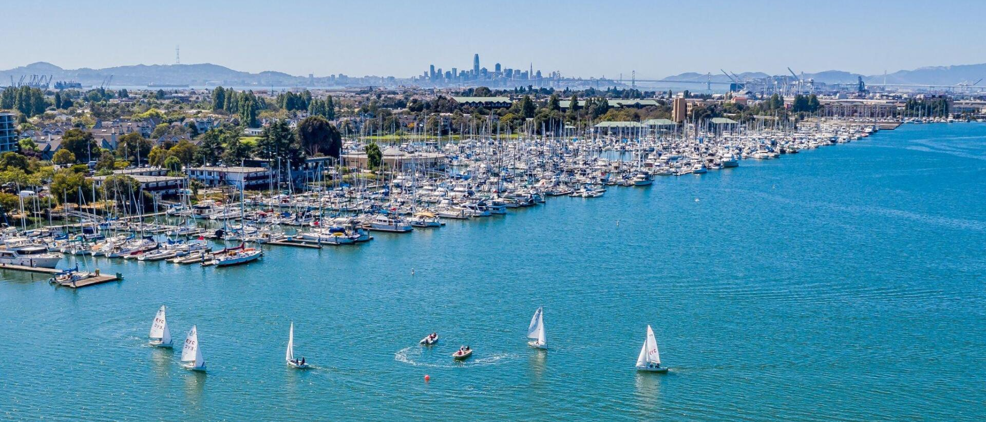A group of sailboats are floating on top of a large body of water.