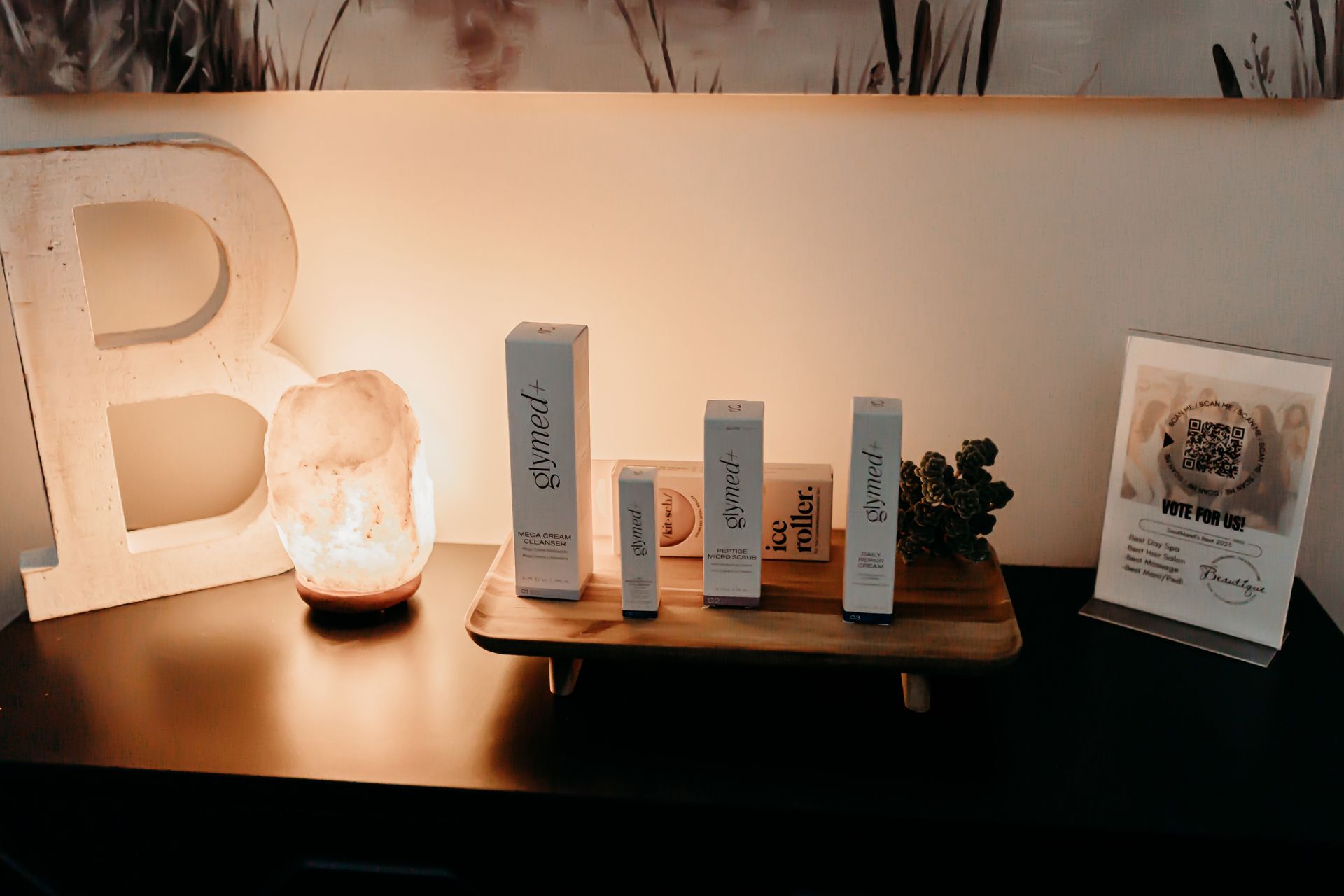 A table with a tray of cosmetics and a lamp on it.