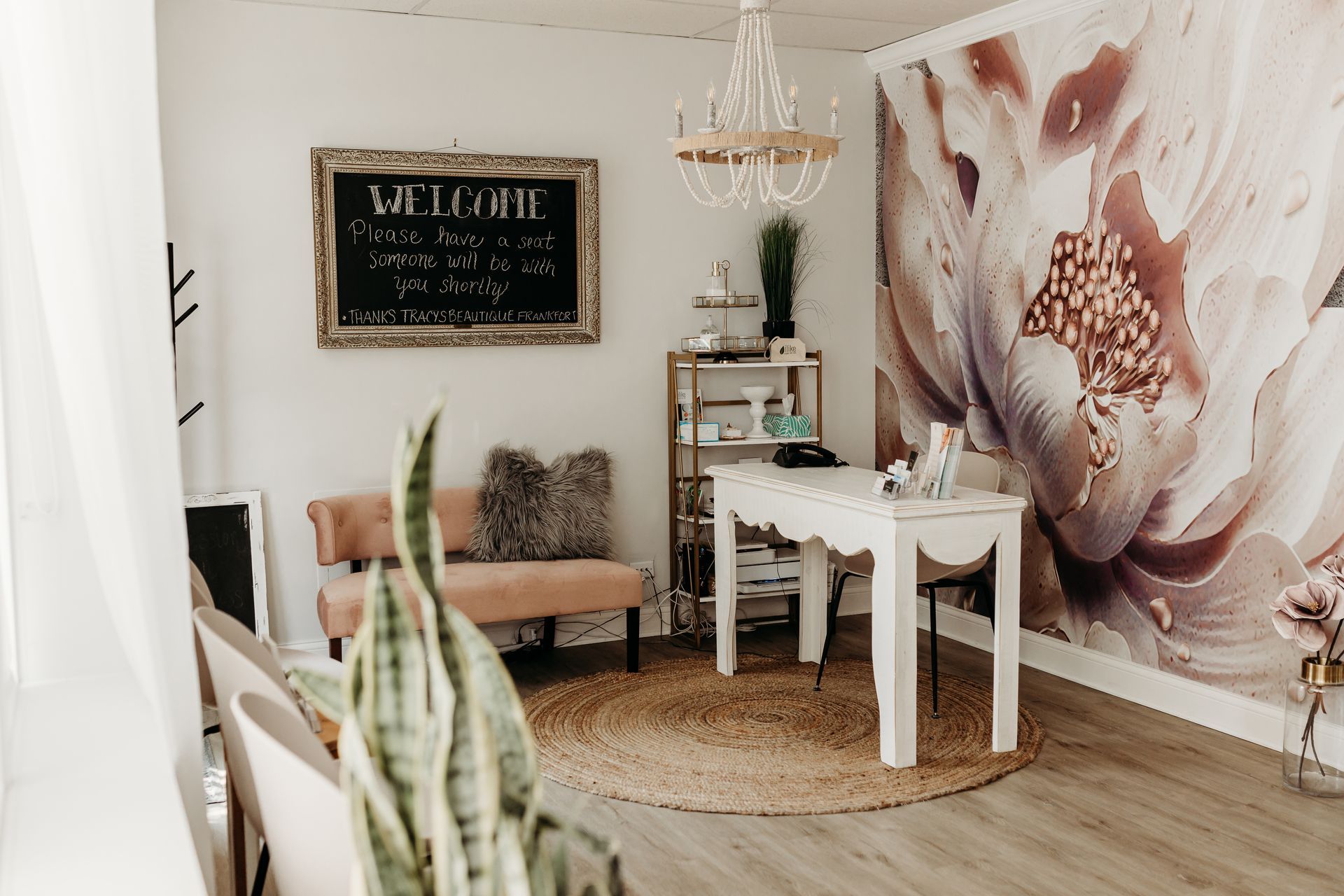 A waiting room with a table and chairs and a large floral wall mural.
