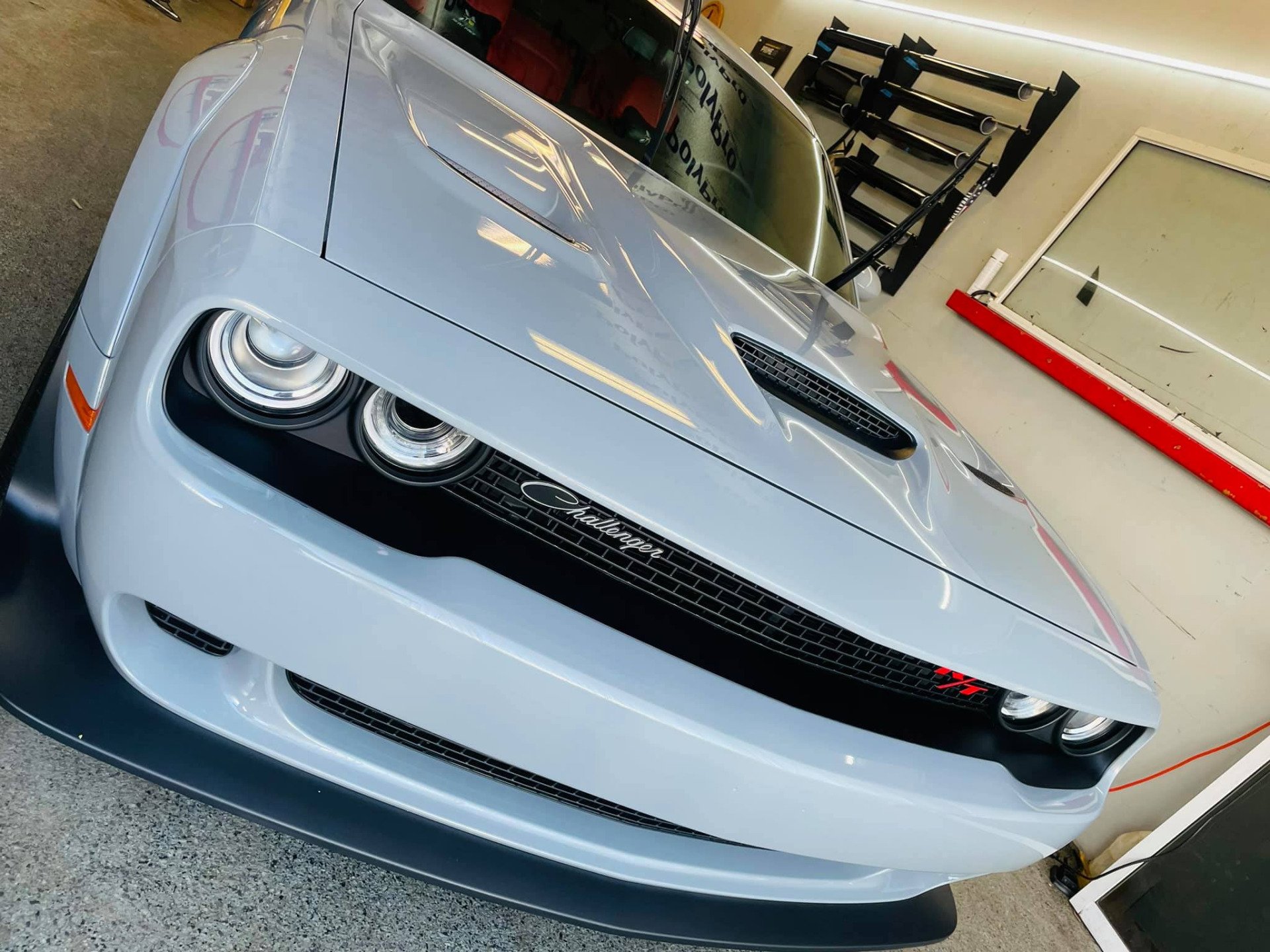 Dodge Challenger in gray with black accents, parked inside a garage.