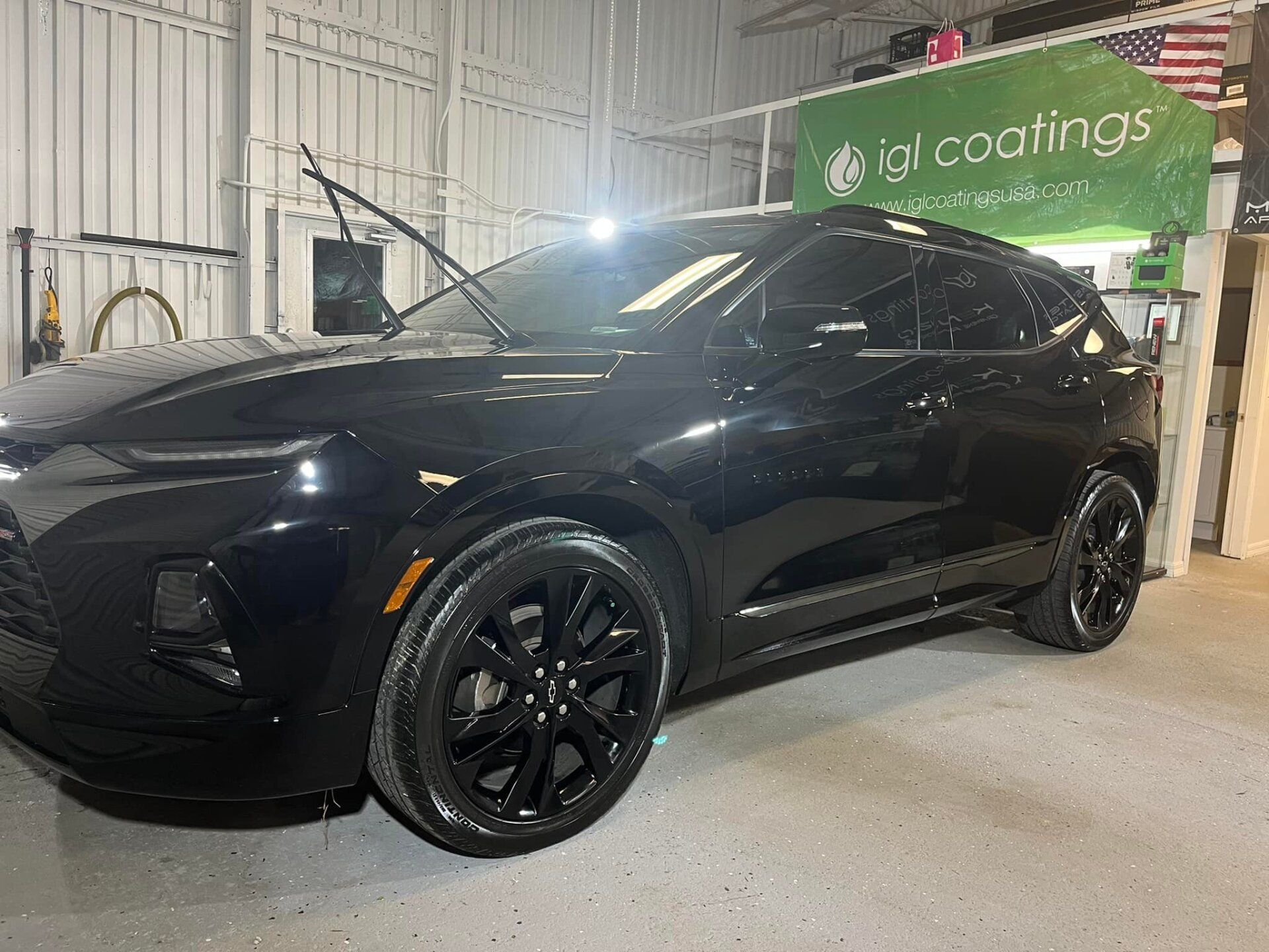 Black Chevrolet Blazer in a garage, receiving a protective coating.