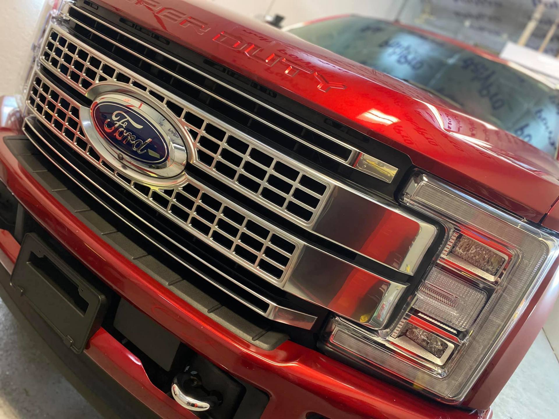 Red Ford truck front grill with chrome accents and Ford logo.