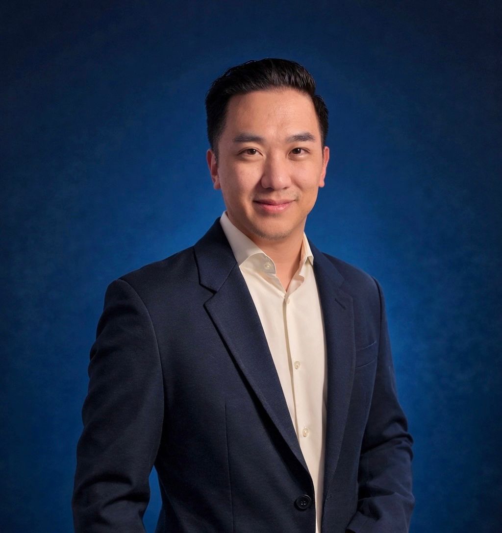 A woman with curly hair is wearing a purple dress and a black jacket.