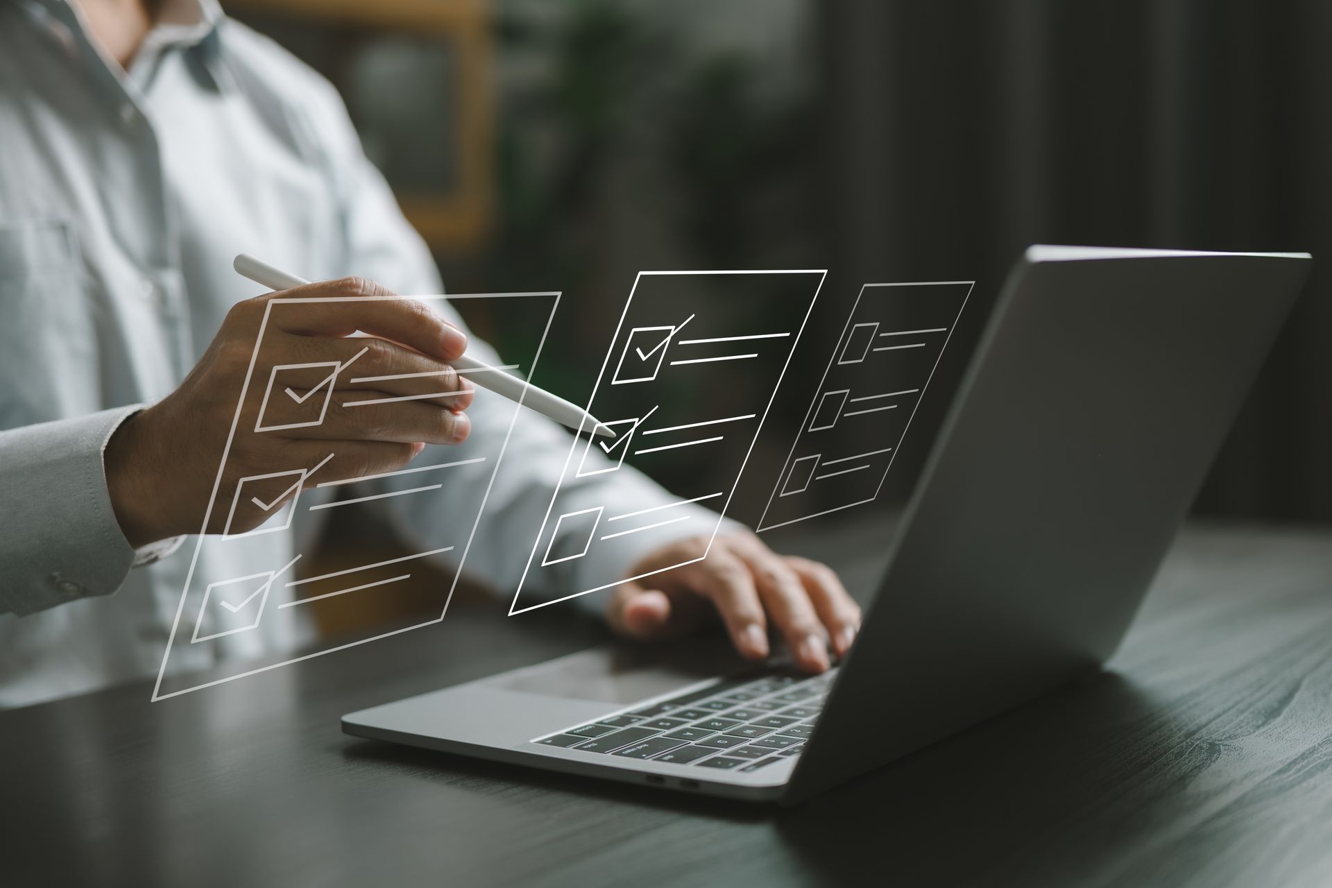 Person using laptop, digital checklists overlayed, confirming tasks with stylus.