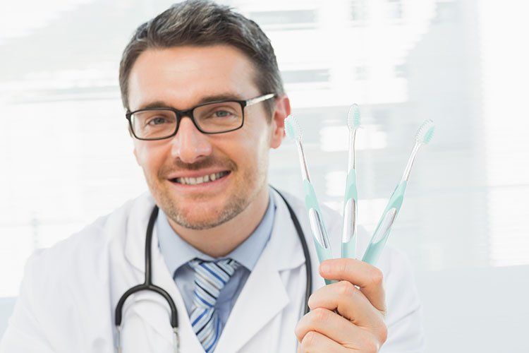 entist holding toothbrush - Dental Care in Sumter, SC