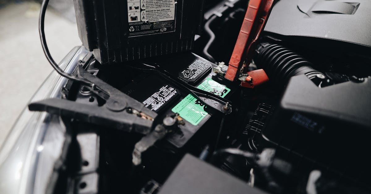 A close up of a car battery with the hood open. | MasterTech Auto Care