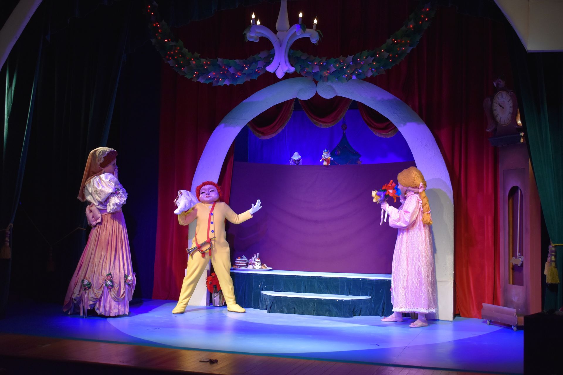 A group of people in costumes are standing on a stage.