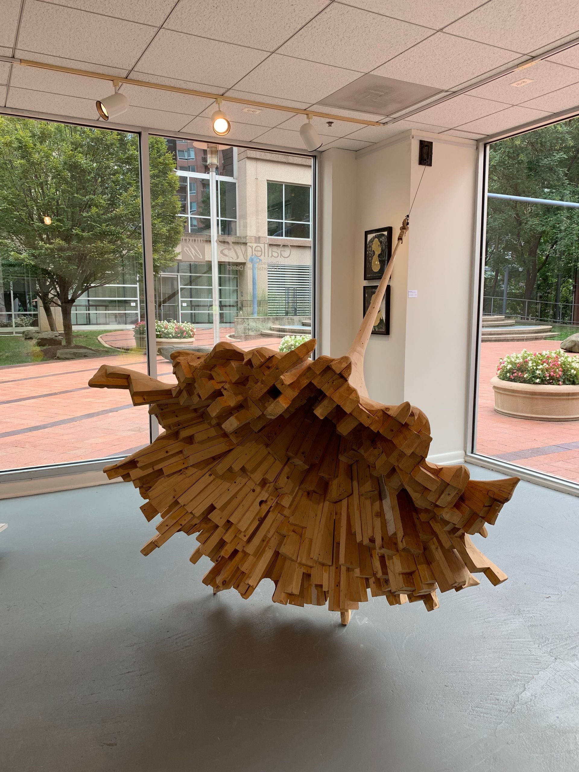 A large wooden sculpture is hanging from the ceiling in a room.