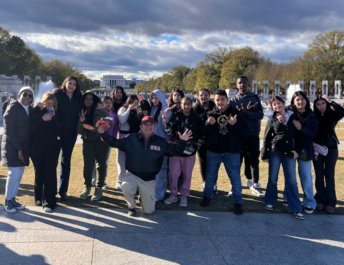 A group of teens are posing for a picture on the DC Mall.