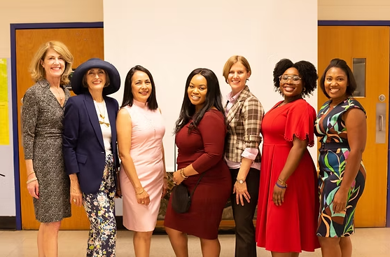 Carol trawick with a group of women are posing for a picture together in a room.