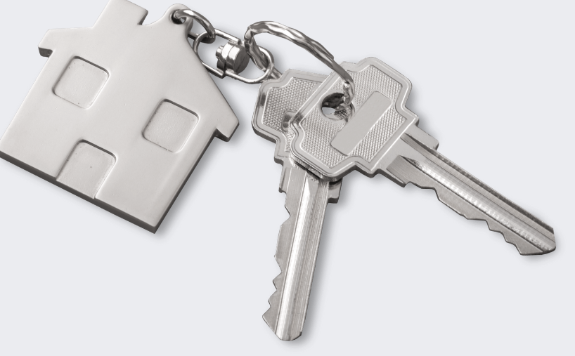 A pair of keys with a house keychain attached to them