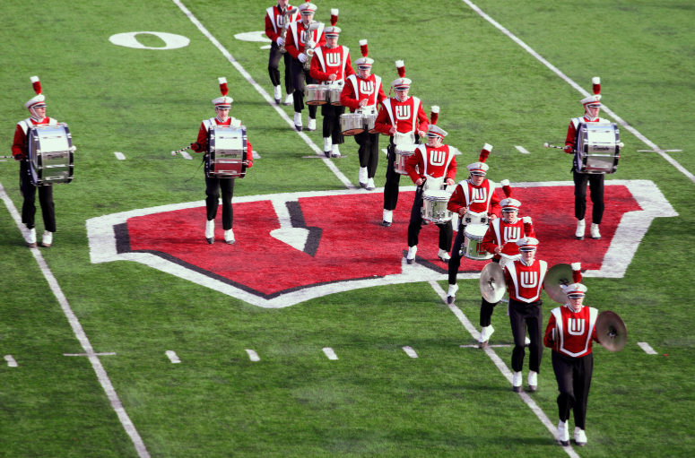 A marching band is marching on a football field