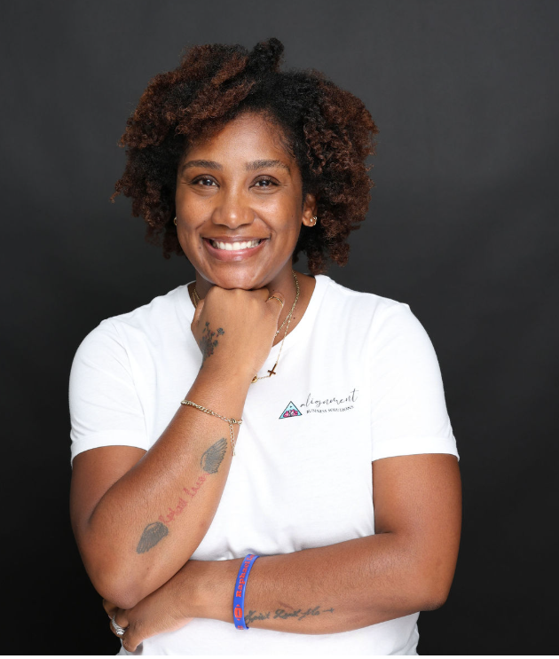 A woman is sitting in a chair talking on a cell phone