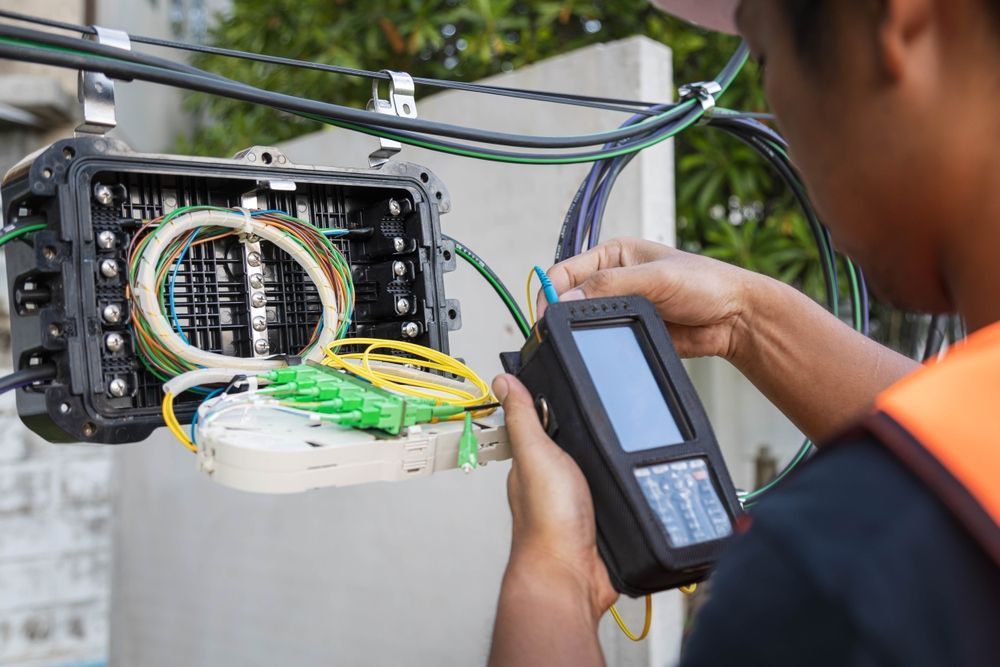 A man is working on a telephone pole while holding a device.