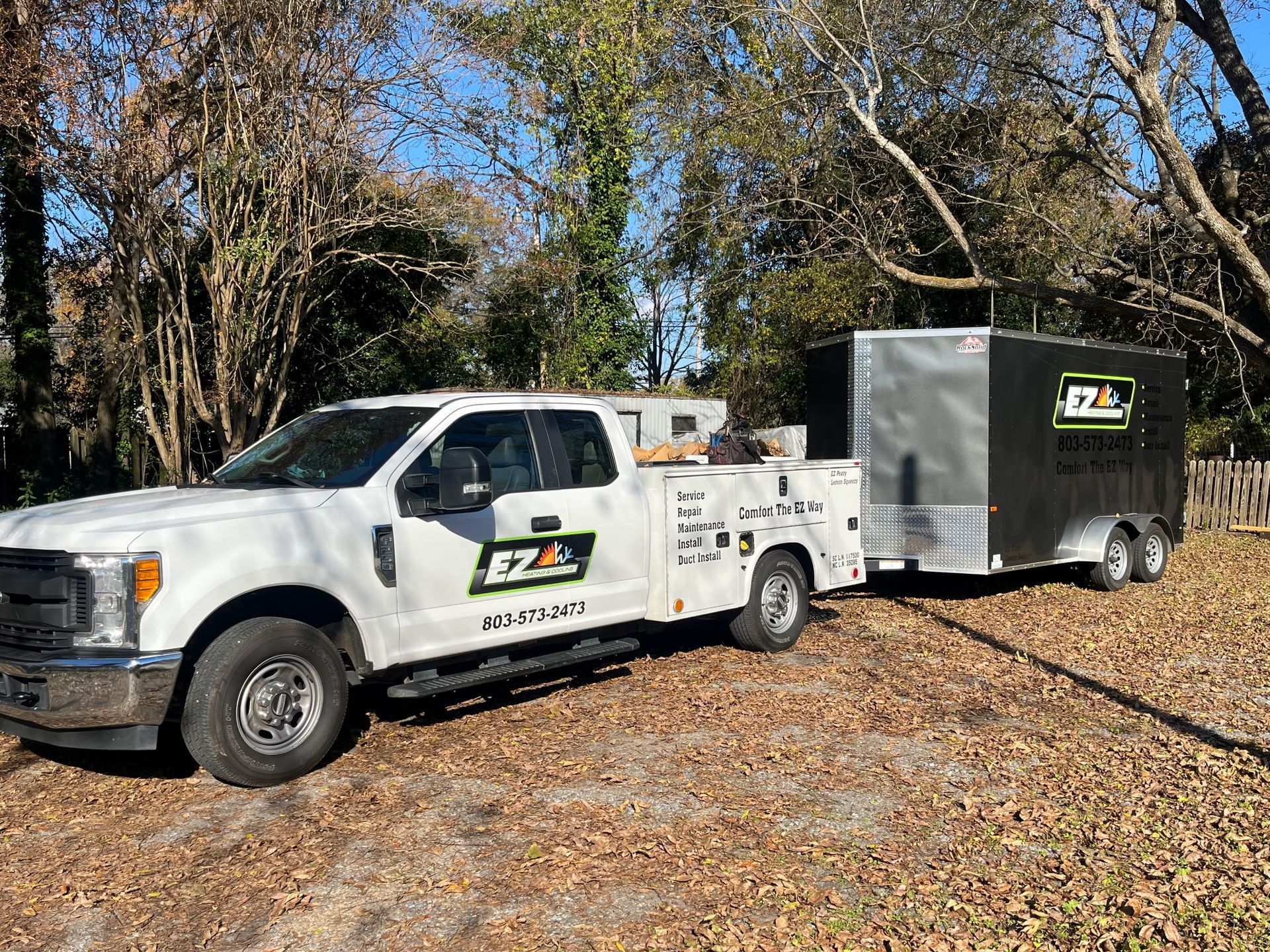 White pickup truck with a trailer, both branded 