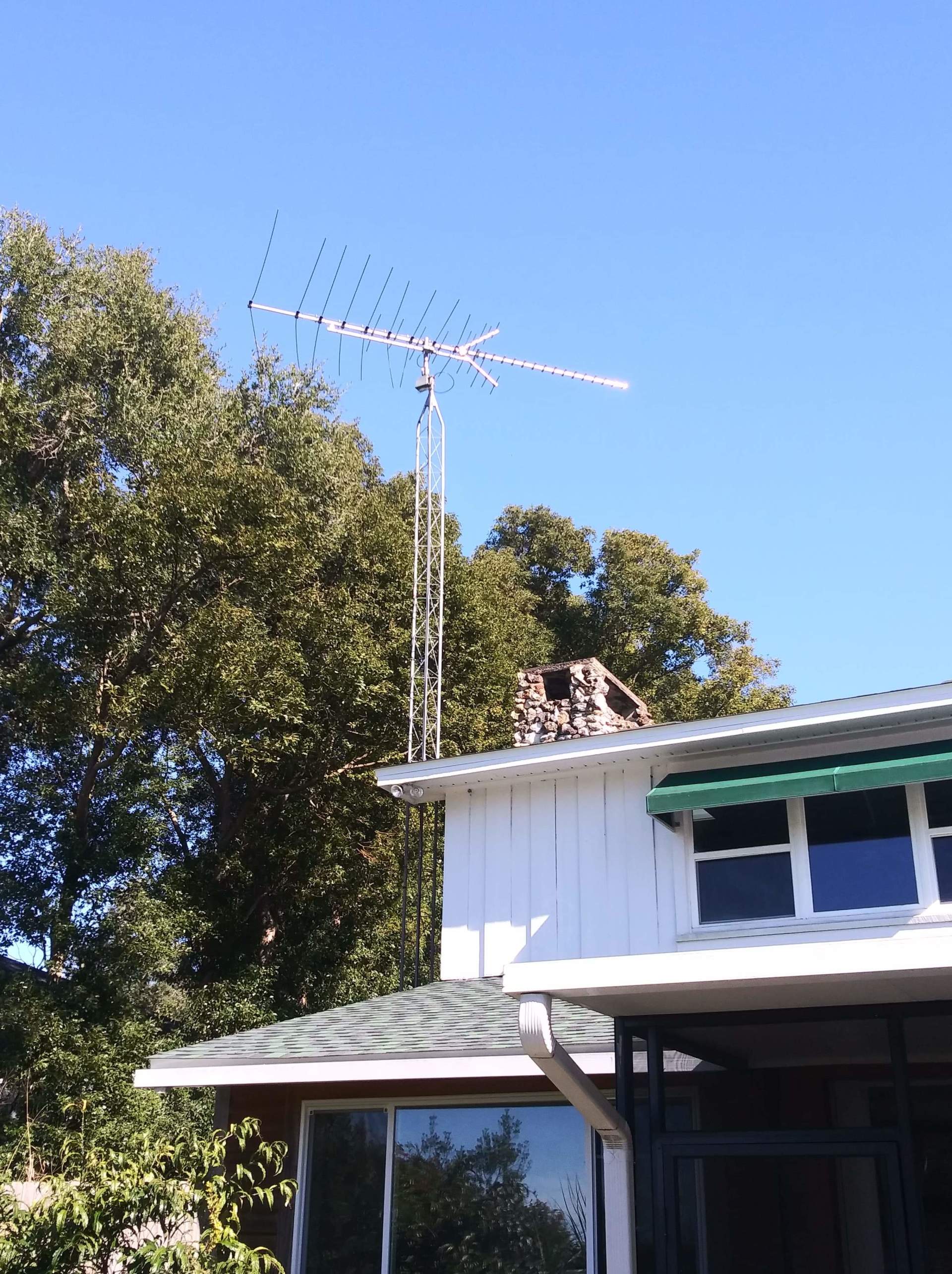A white house with an antenna on top of it