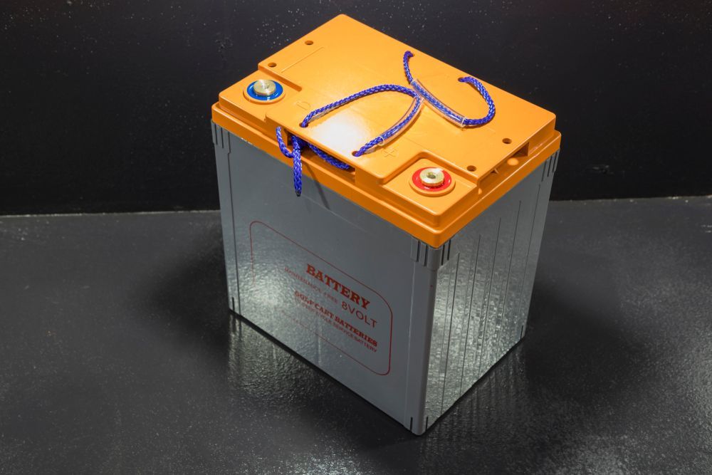 Orange-topped Grey Battery With Red Text — Cairns Electrical Rewinds & Repairs In Bungalow, QLD