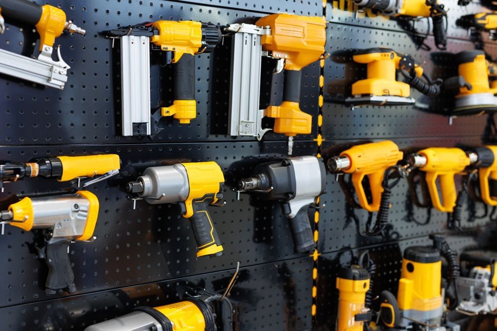 Yellow and Silver Power Tools Hanging on a Black Pegboard — Cairns Electrical Rewinds & Repairs In Bungalow, QLD