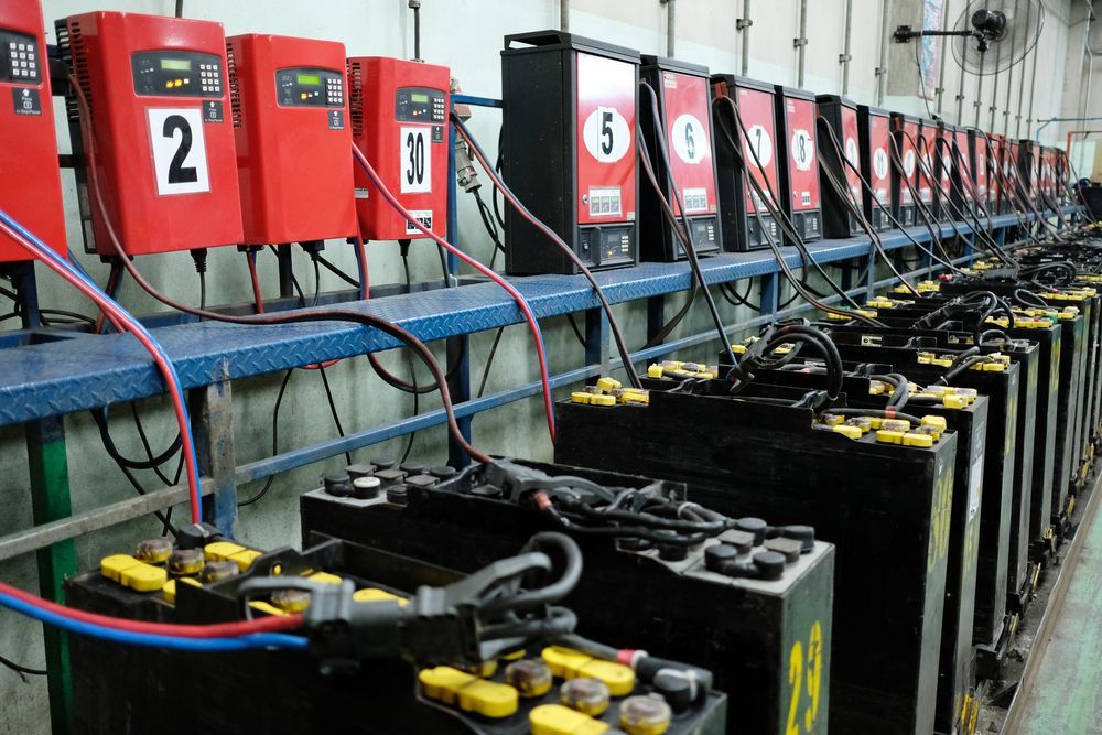 Row of Industrial Batteries Connected to Chargers — Cairns Electrical Rewinds & Repairs In Bungalow, QLD
 