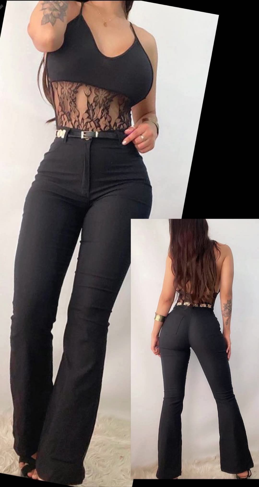 Una mujer lleva un top negro y pantalones negros.