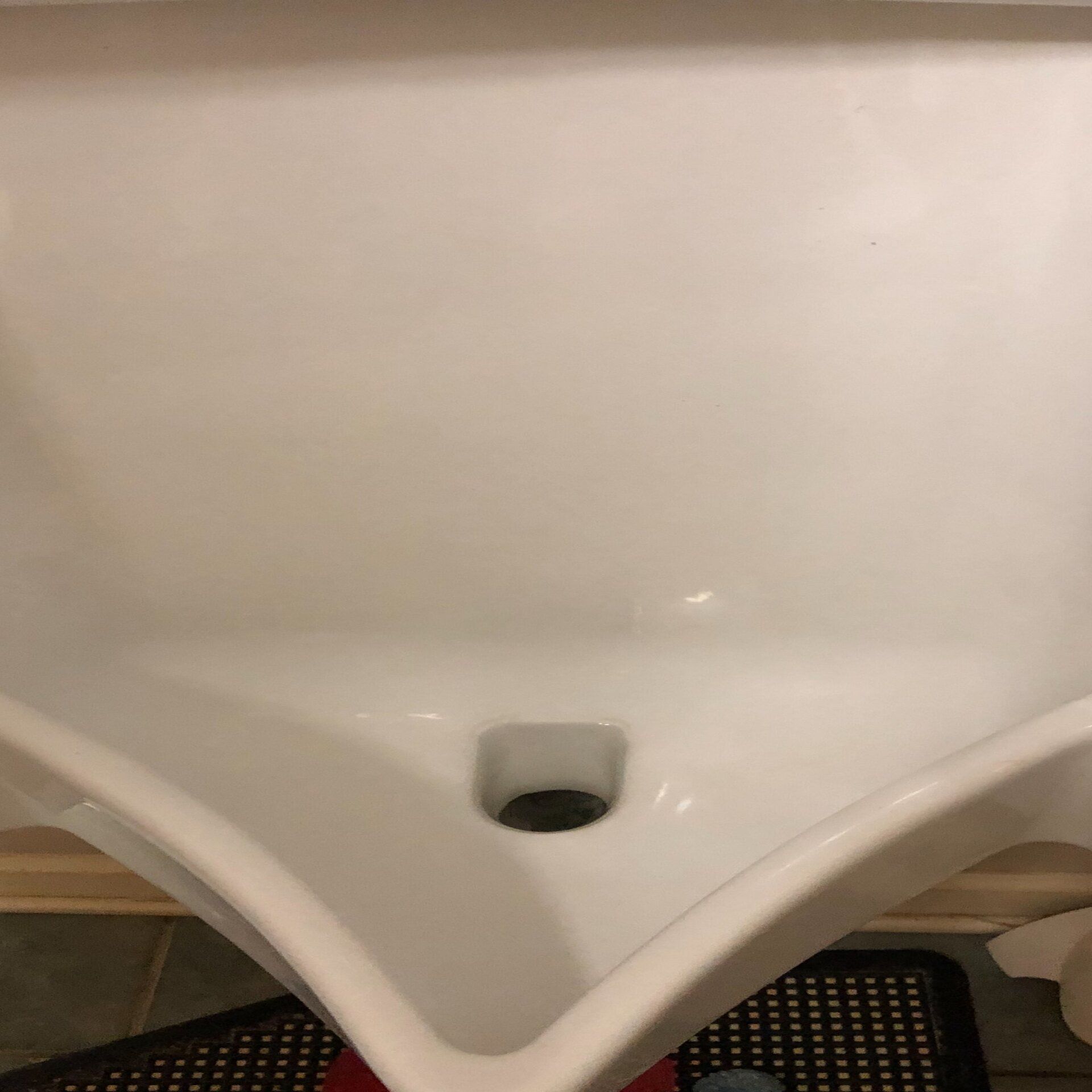 White porcelain sink with a central drain.