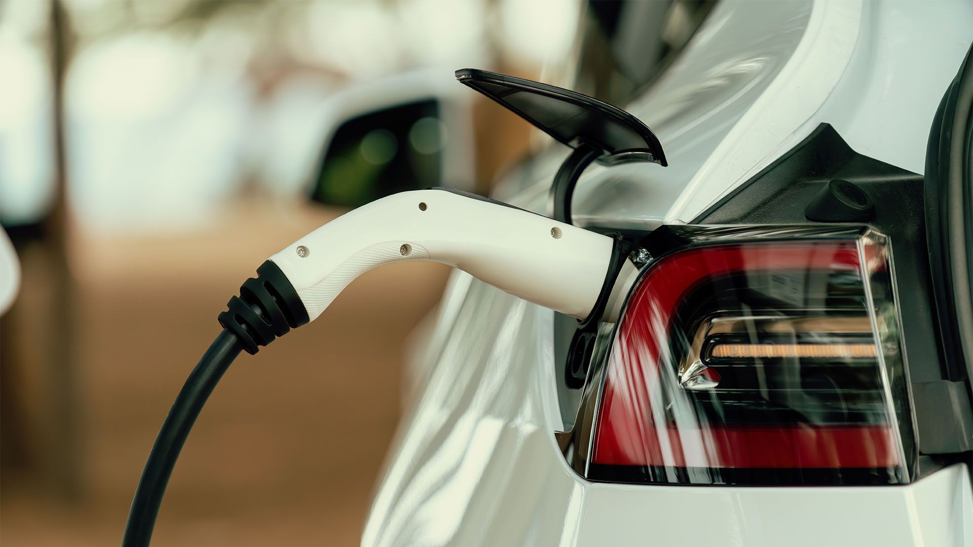 A white electric car is being charged at a charging station.