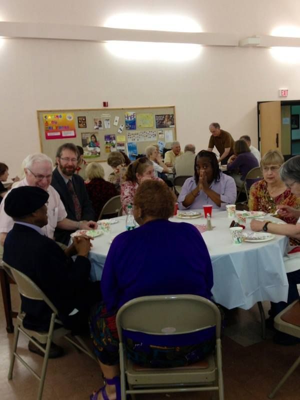People Seated at Round Tables in A Community Room — Amherst, MA — Immanuel Lutheran Church